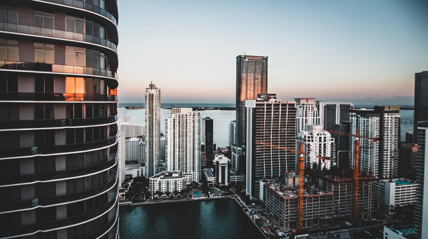 Miami skyline at dusk with high-rise construction cranes
